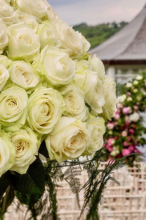 Stunning white rose wedding flower arrangement looking out over at the gazebo for outdoor ceremonies 