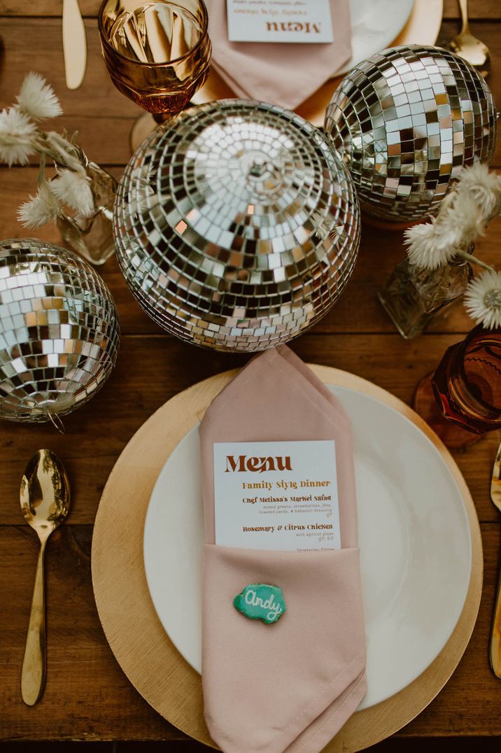 Disco ball table centrepiece with white plate, pink napkin and gold cutlery