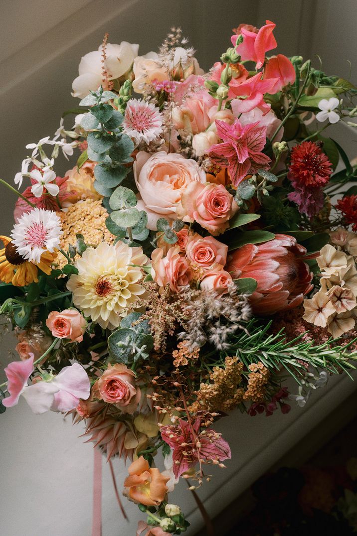 Pink wedding bouquet with sweet peas, roses and dahlias 