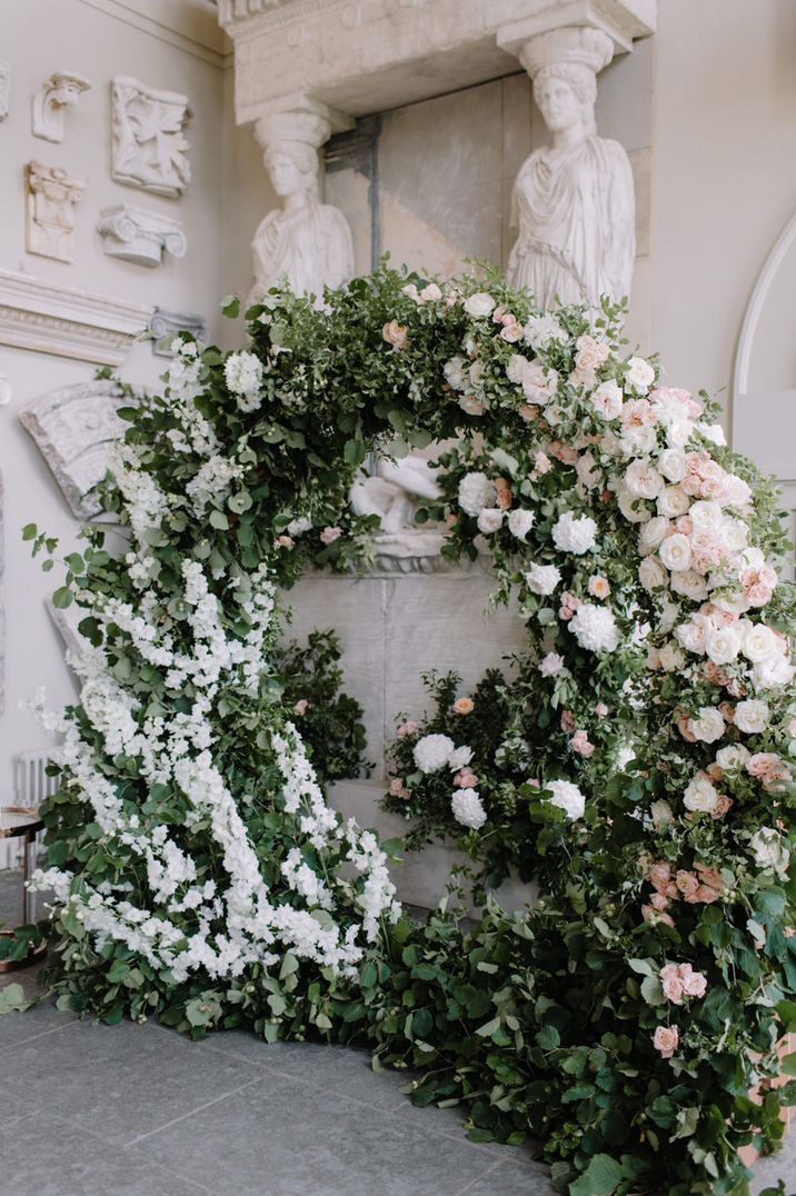 Impressive white, pink and green foliage moon gate flower arch 