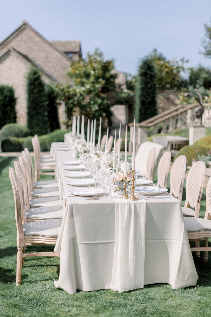 Simple white tablescape for outdoor grand table at traditional wedding