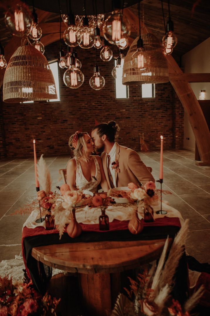 Valentine's Day wedding ideas with the bride and groom sitting at intimate wedding sweetheart table 