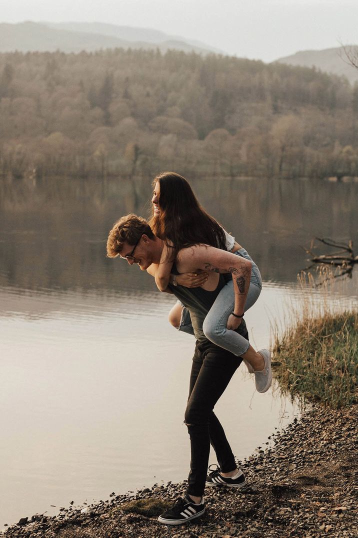 Man lifts his fiancee onto his back for a piggyback ride 