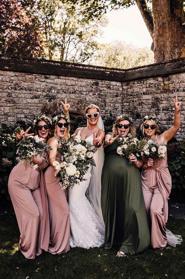 Bride and bridesmaids in pink and green dresses and sunglasses 