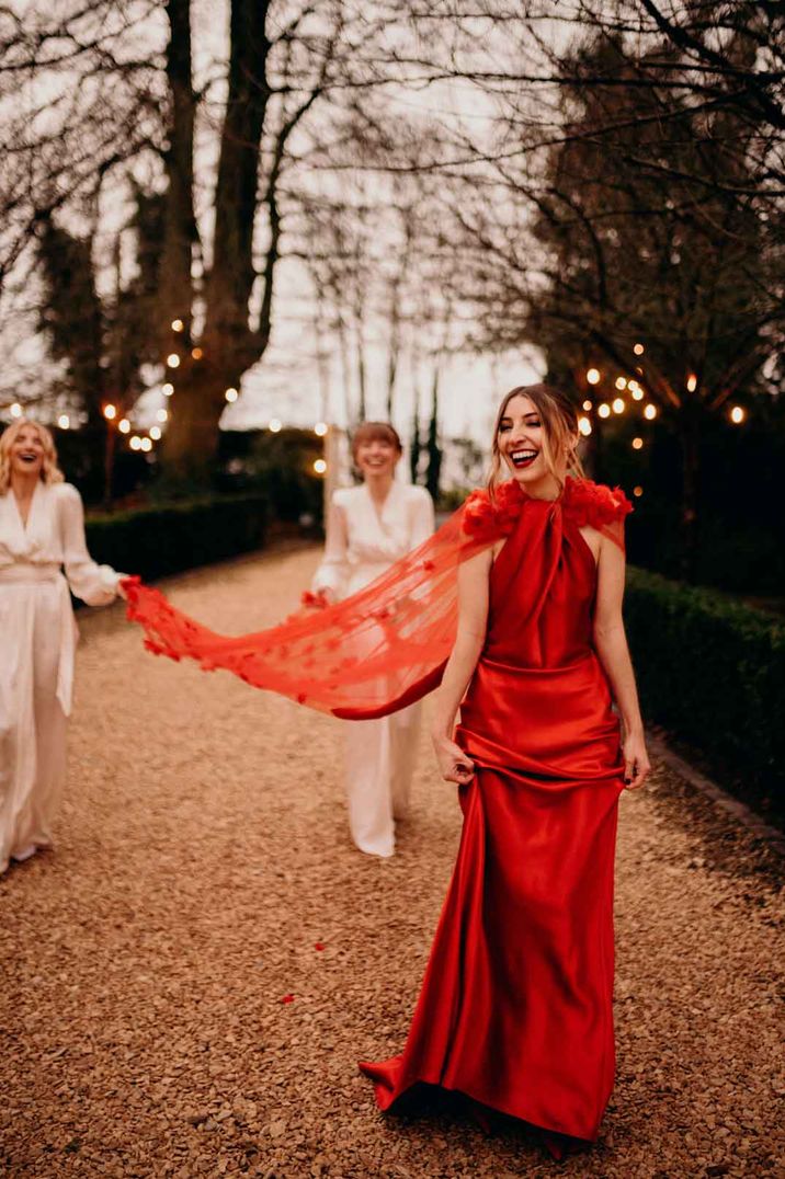 Bride in satin red wedding dress with halter neck and 3D appliqué red rose veil 