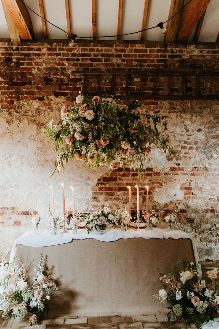 Beige wedding table cloth with pink and white wedding flower decorations on sweetheart table 