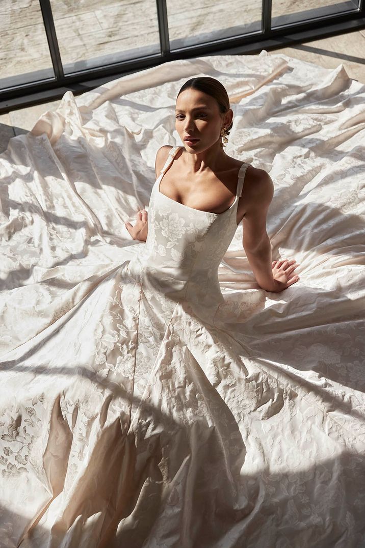 Bride laying on the floor in pale pink dropped waist wedding gown 