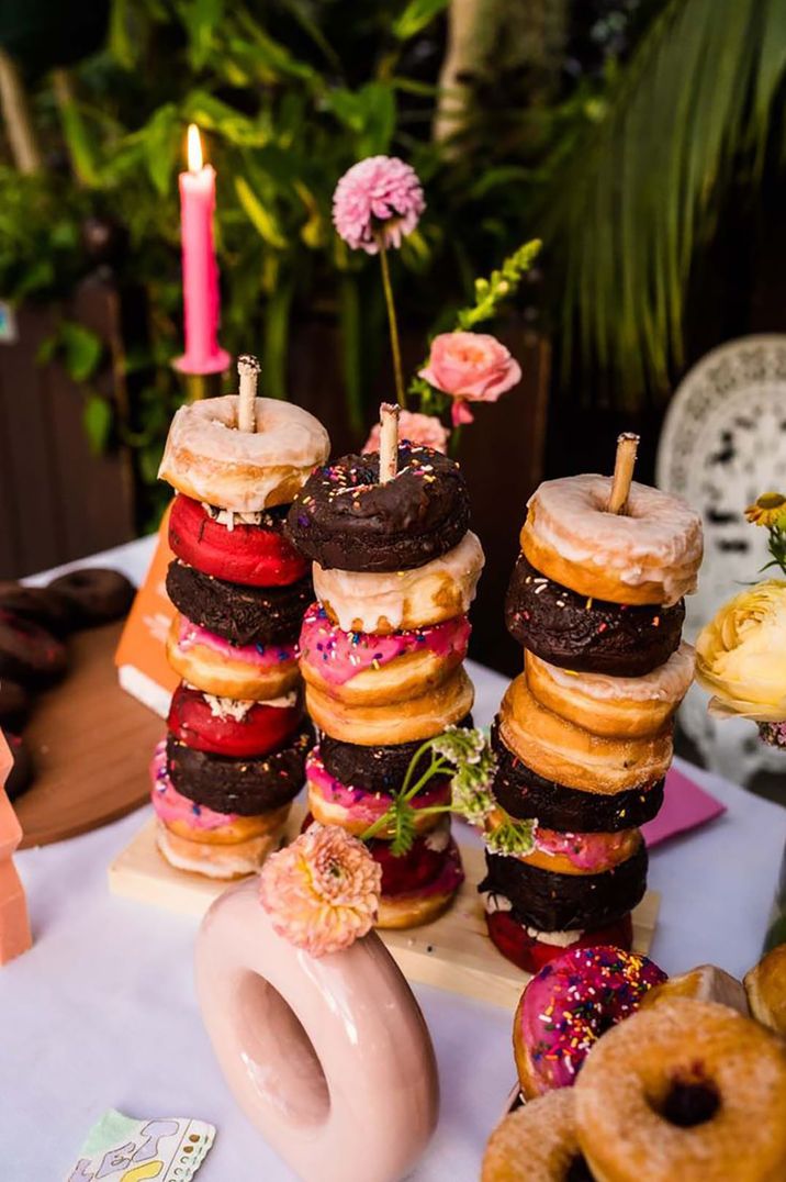 Doughnut tower with glazed doughnuts, chocolate doughnuts and pink sprinkle doughnuts 