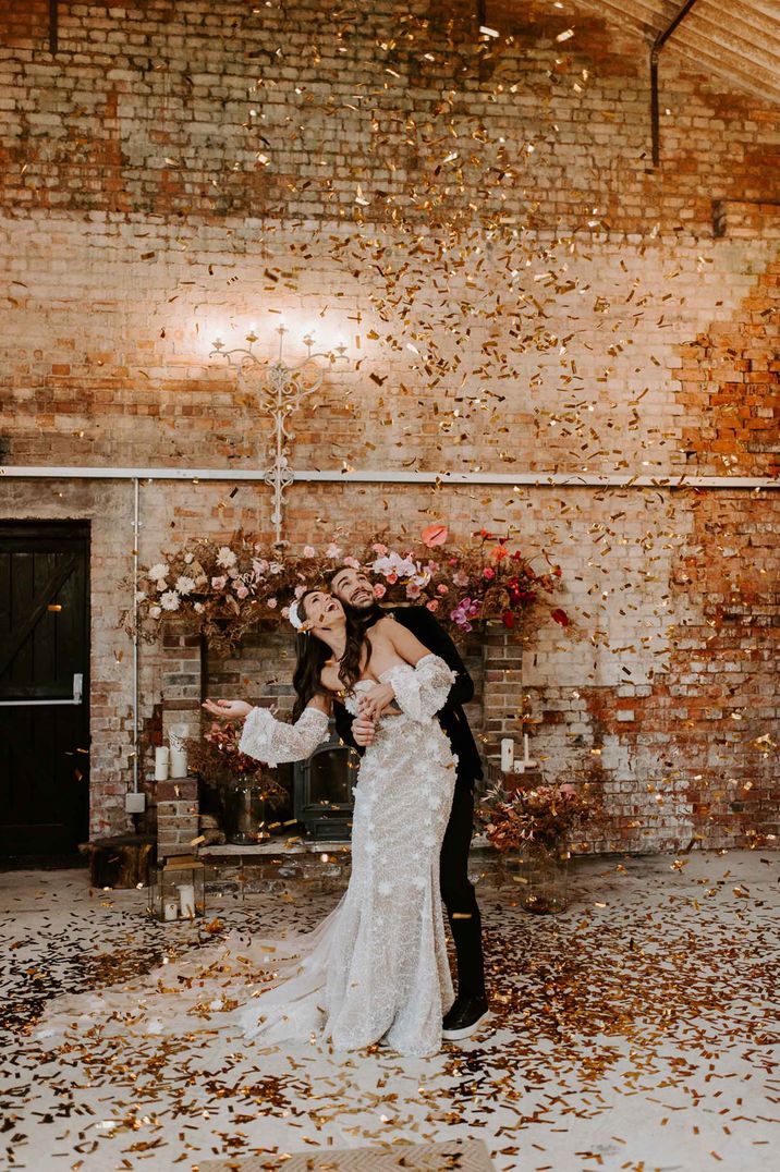 Confetti moment with bride in a lace wedding dress with detachable long sleeves