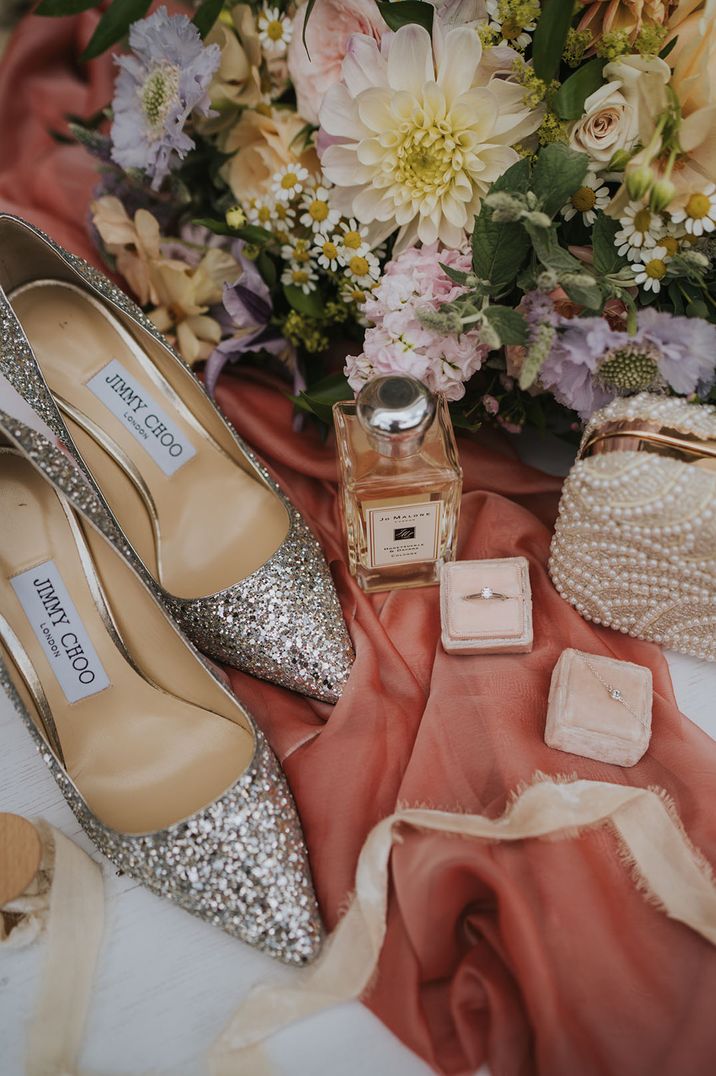 Bridal accessories wedding photo with sparkly Jimmy Choo wedding shoes, Jo Malone wedding scent, wedding jewellery, and the bridal bouquet