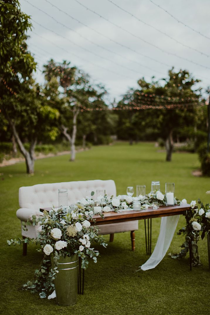 White sweetheart sofa for outdoor wedding breakfast with table for the newlyweds 