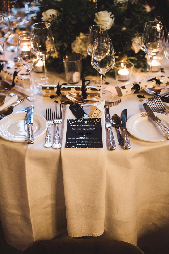 Christmas wedding tablescape with black and gold theme including Christmas crackers 