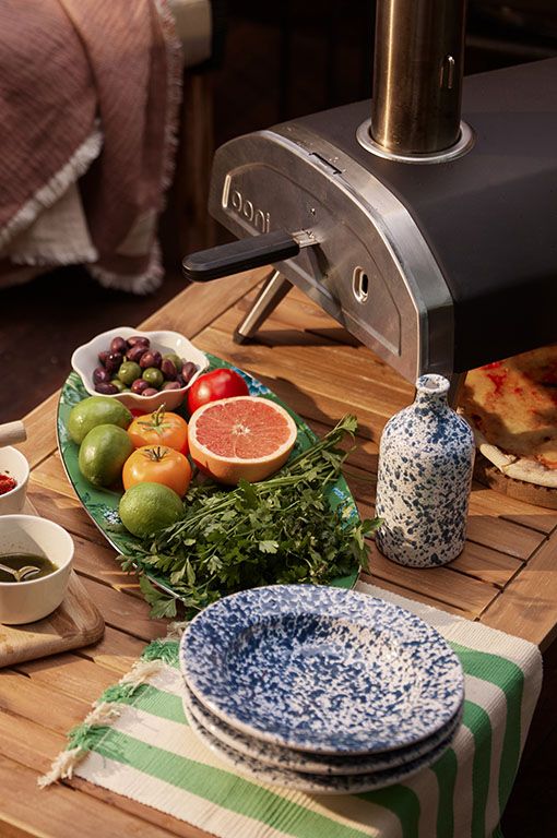 pizza oven with speckled crockery and fresh garnishes 