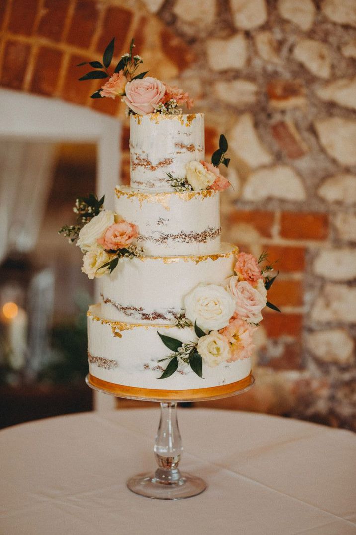 White semi=naked wedding cake with gold leaf and flower decoration