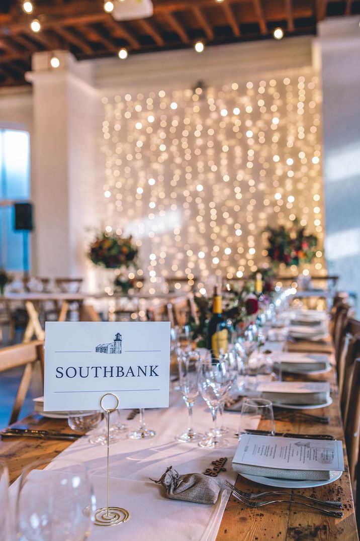 London table names with fair light backdrop at The Chainstore Trinity Buoy Wharf wedding venue