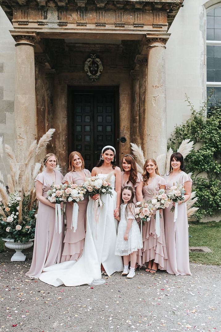 Bridal party shot with the bridesmaids in pink bridesmaid dresses, and flower girl in white polka dot dress and bride in Jesus Peiro wedding dress 