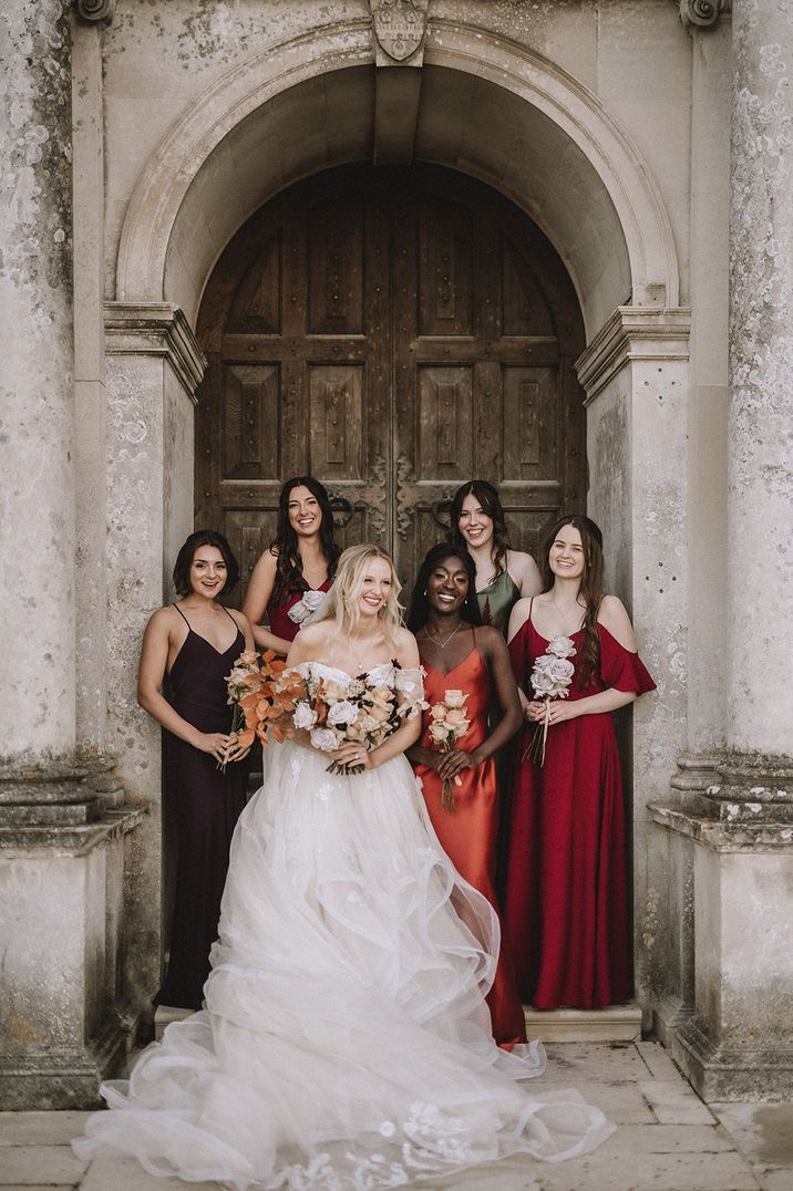 Bridesmaids in mismatched bridesmaid dresses with the bride for epic castle wedding 