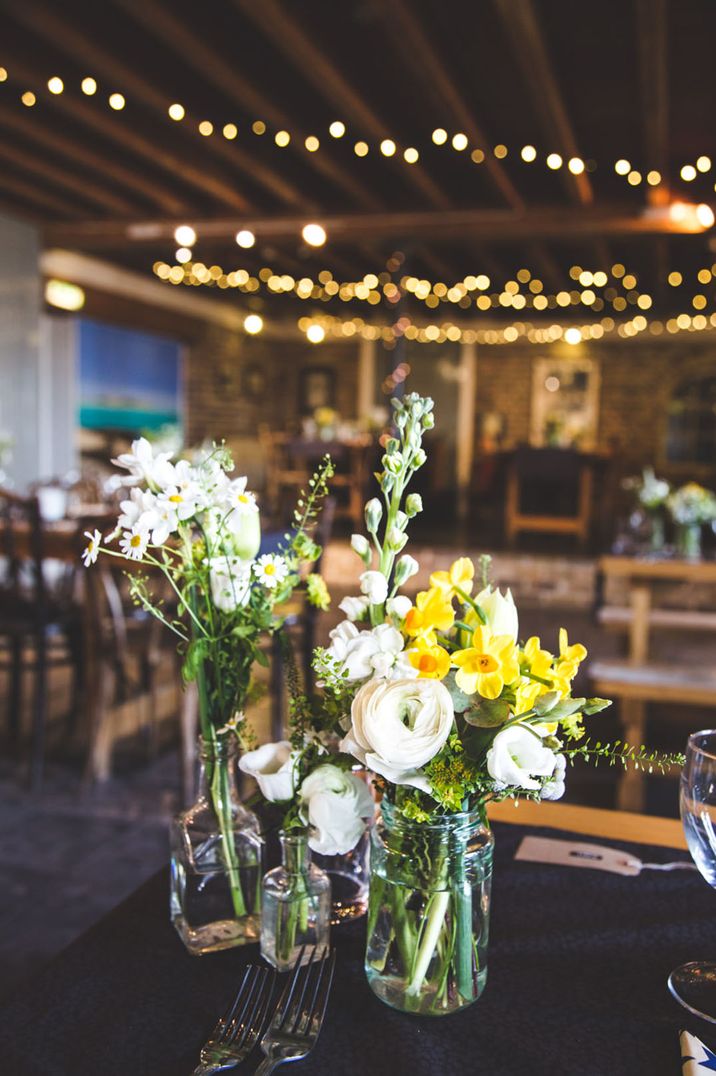 Daffodil wedding flowers based on March birth flowers with white flowers in glass vases 