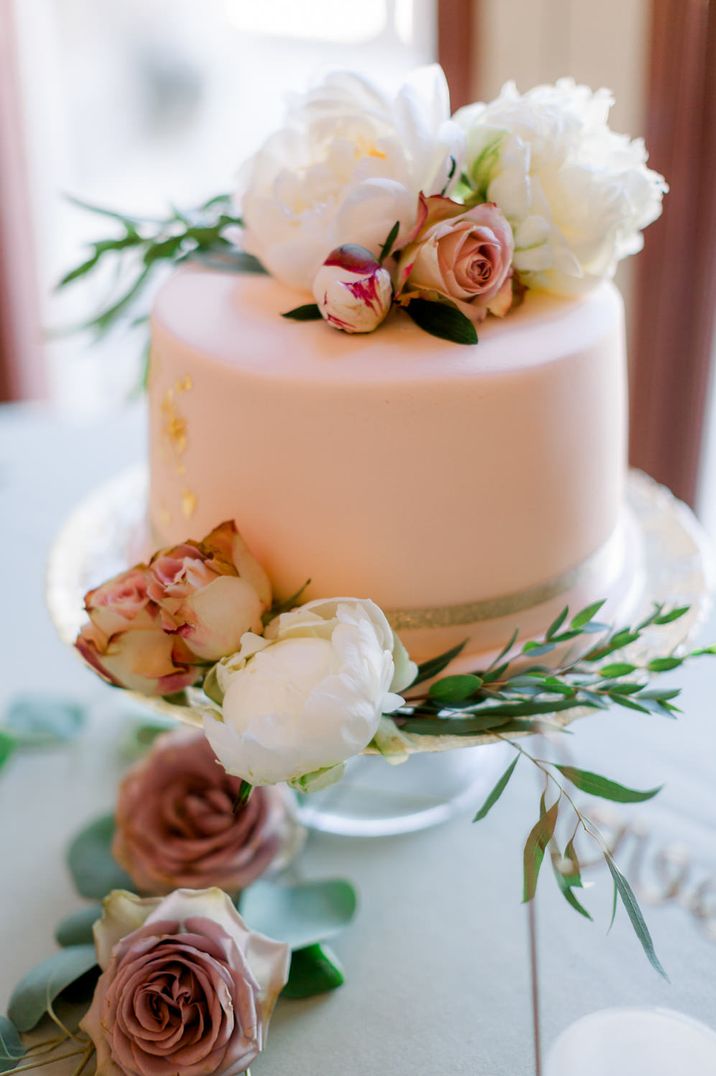 Single tier iced blush pink wedding cake with floral decor