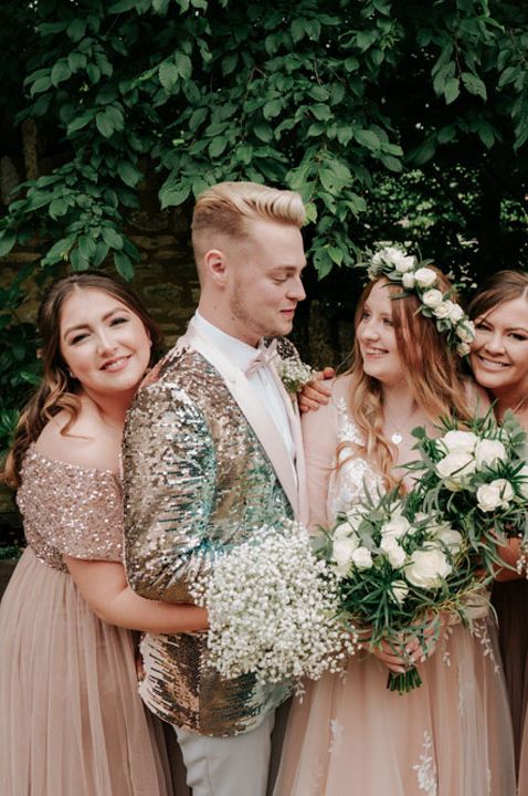 Mixed gender wedding party with bridesman in sequin jacket and bridesmaids in pink sparkly bridesmaid dresses