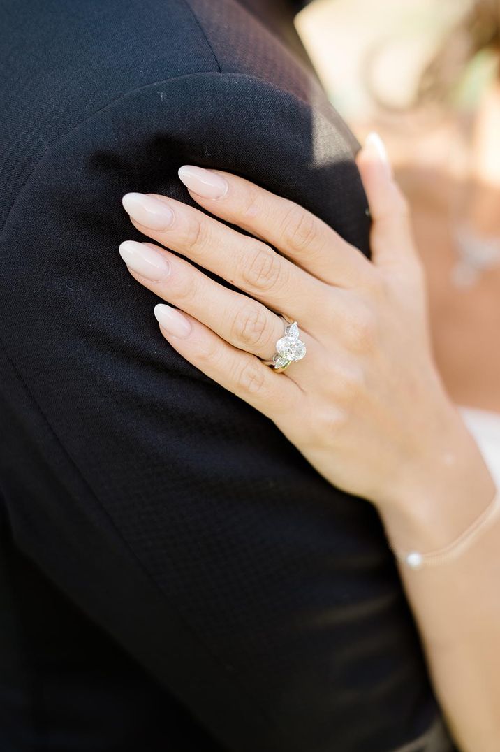 Bride with neutral wedding nails with oval diamond engagement ring with baguette diamonds 