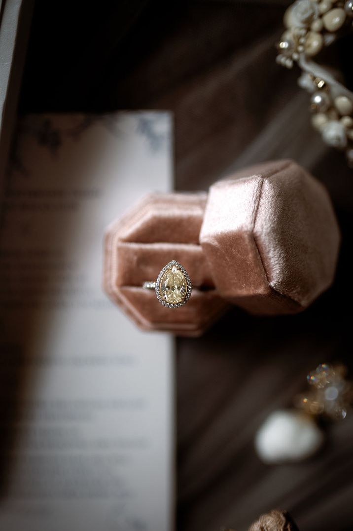 Pink velvet ring box with pear shaped yellow diamond halo engagement ring 