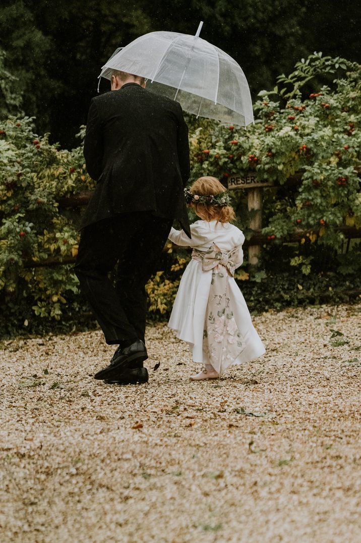 Young flower girl in an ivory dress with floral bow back detail 