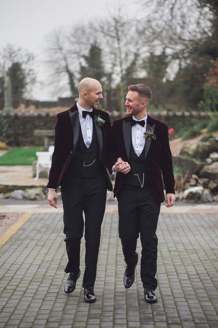 Two grooms in black tuxedo suits serve as perfect gay wedding inspiration