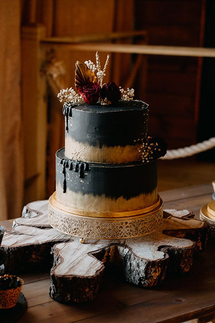 Two tier black and gold wedding cake with red rose wedding decor 