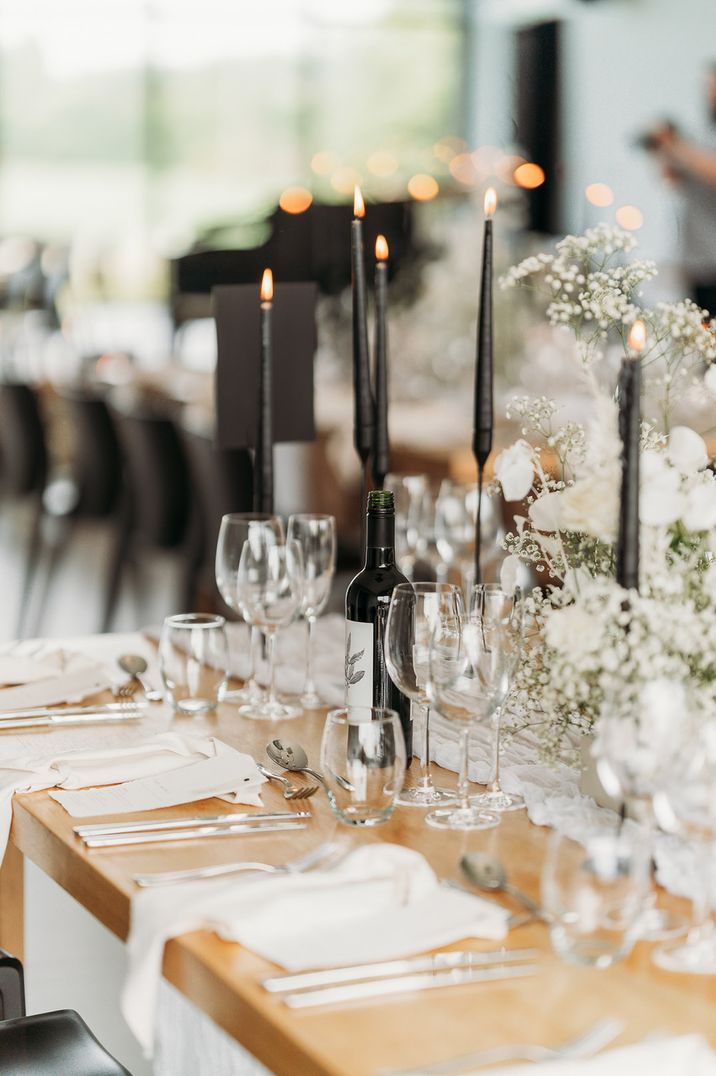 Black taper candles with white gypsophila table decorations for monochrome wedding 