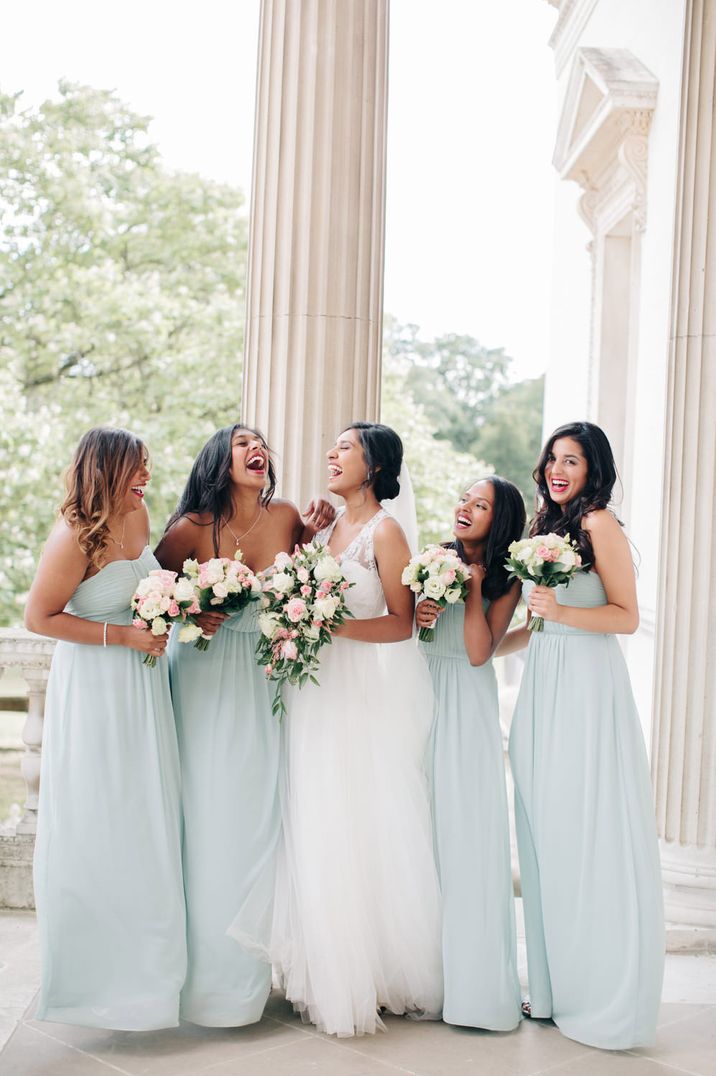 Bridesmaids in mint green strapless wedding dress with white and pink rose bouquets with bride in tulle wedding dress