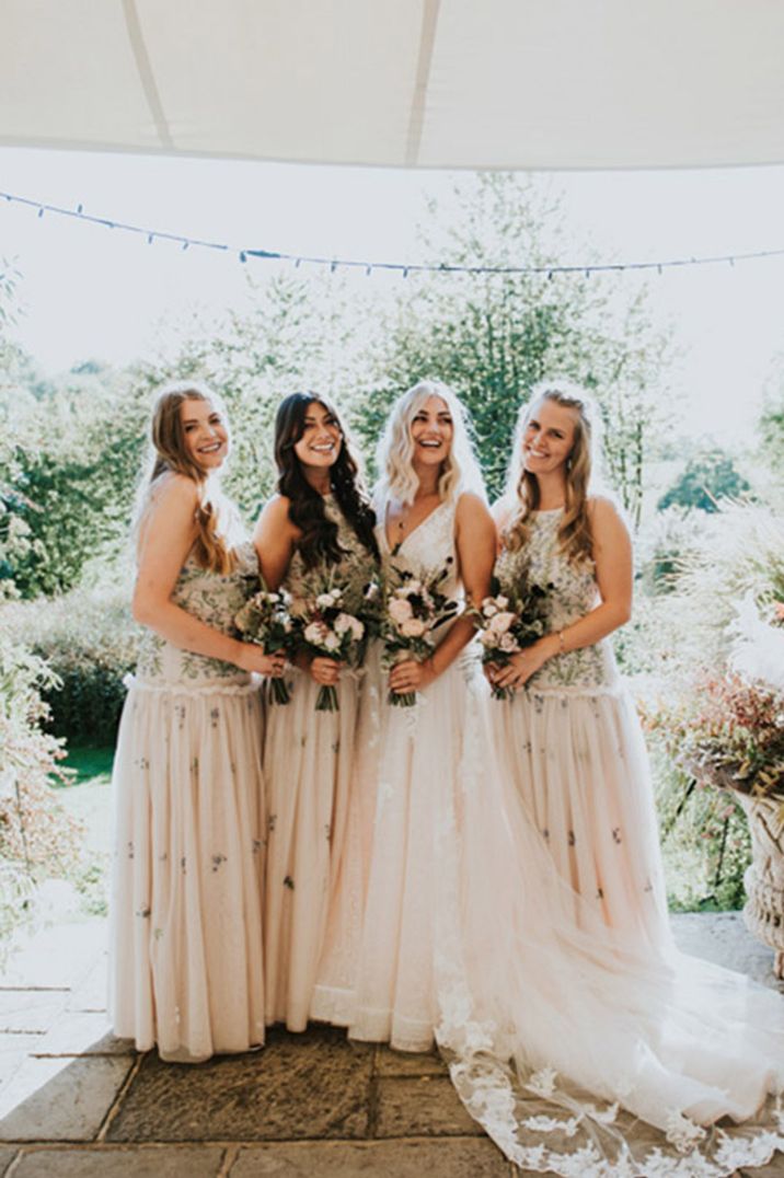 Bridesmaids in pink dresses with floral embroidery and drop waist detail 