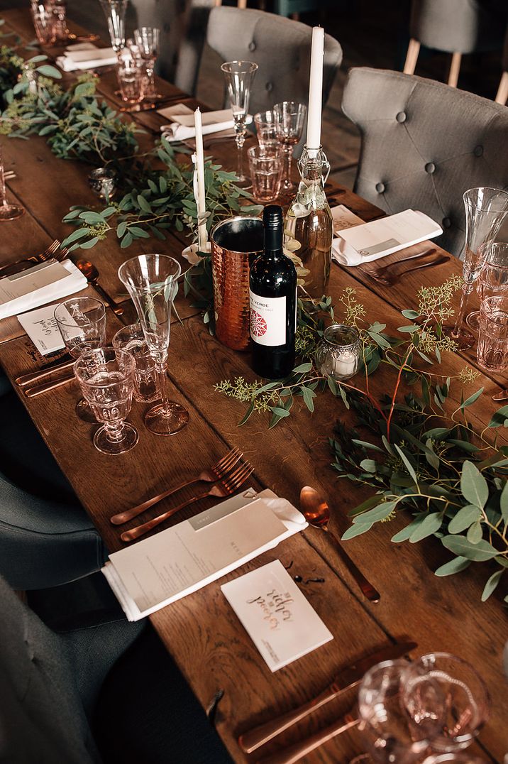 Rustic wedding table decor with foliage table runner, taper candles and tea lights 