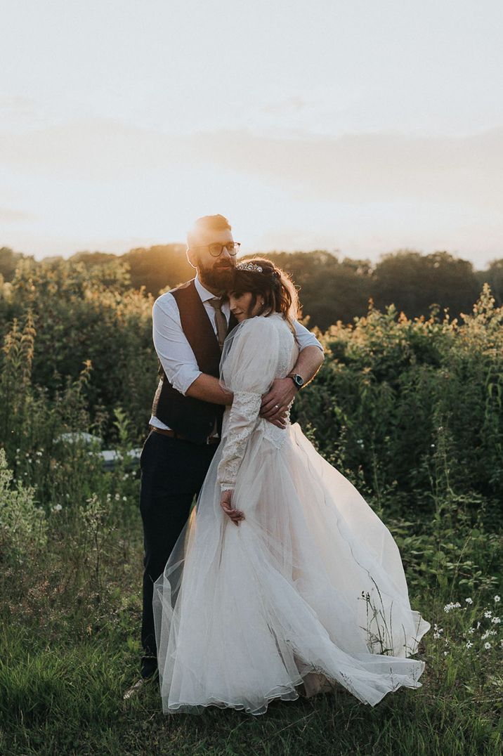 Newlyweds at their LGBTQI+ wedding embrace amid greenery and foliage