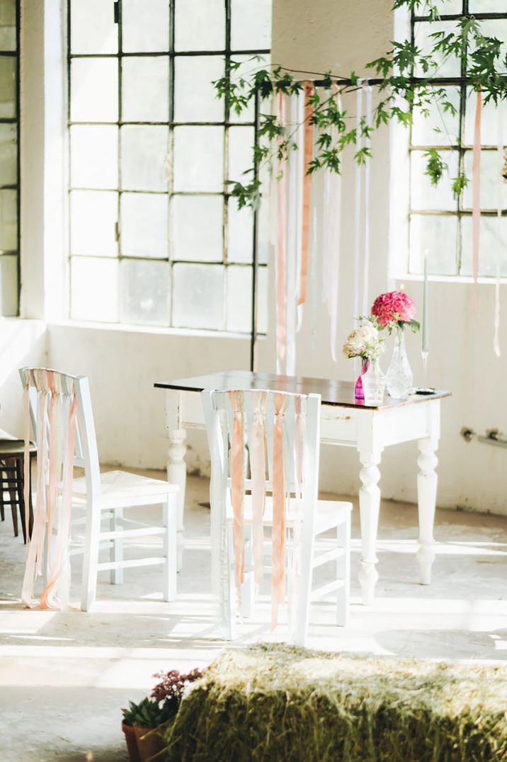 Peach, pink, and white ribbons decorate the bride and groom's ceremony chairs to match the altar decoration 