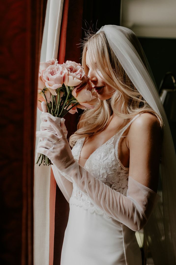 Bride wears sheer gloves and embellished wedding dress