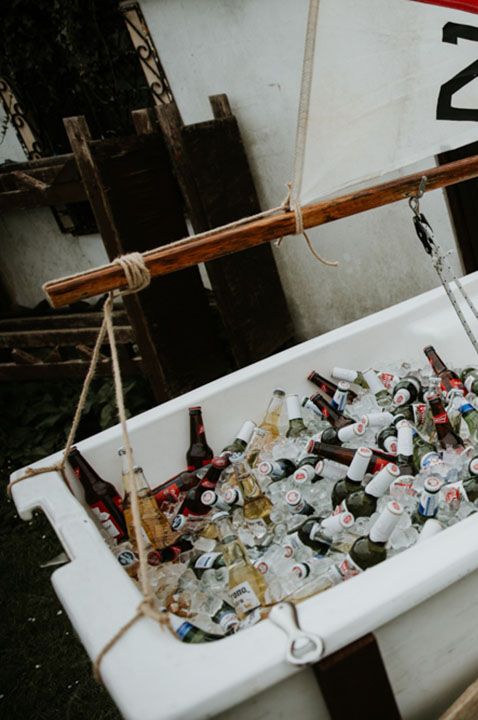 Mini white boat with full of glass bottles of beer for wedding guests to help themselves to 