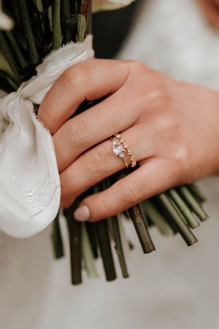 Bride wearing a beautiful diamond and gold engagement ring with spaced diamond wedding ring both protected by wedding insurance 