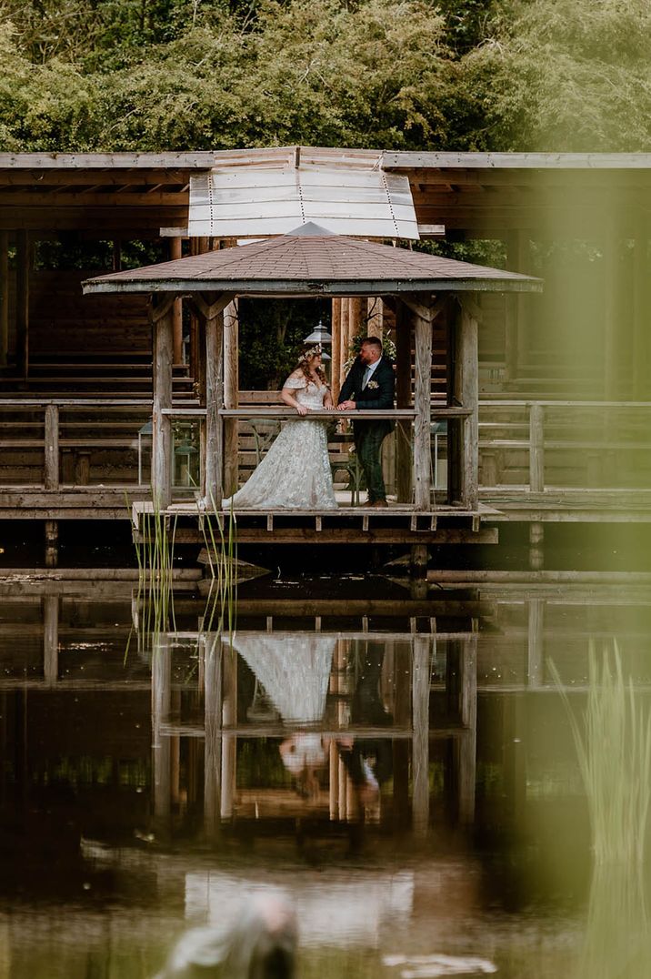 The bride and groom pose for a romantic couple portrait in the gazebo 