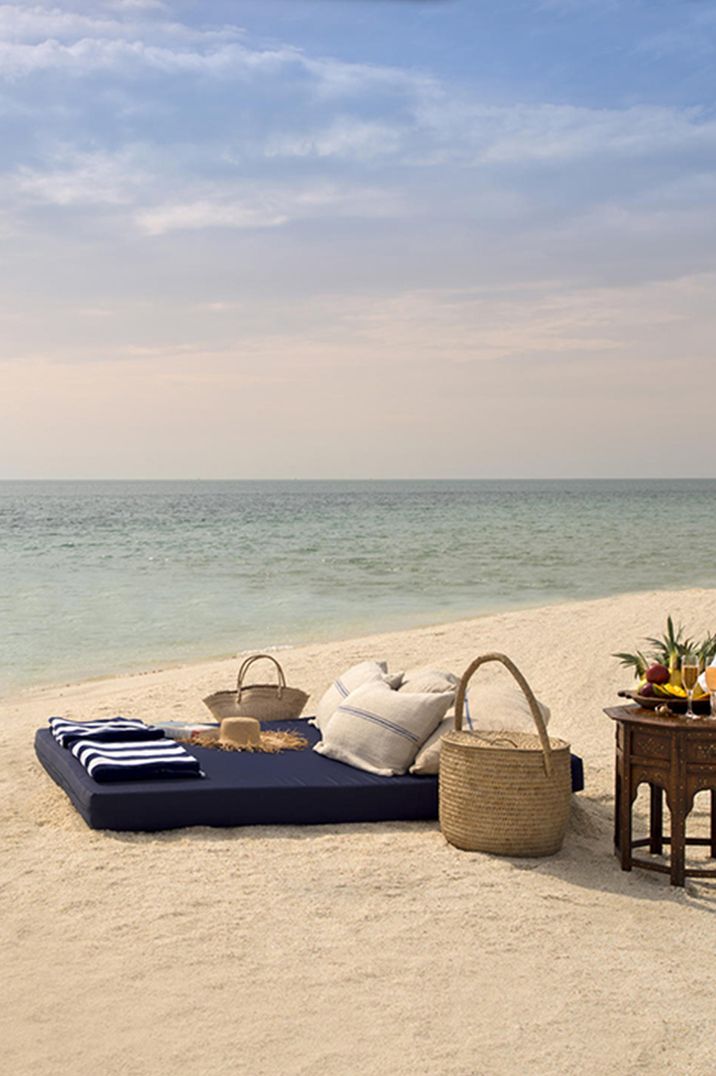 Picnic beach set up with wicker picnic basket for newlyweds to enjoy on their honeymoon 