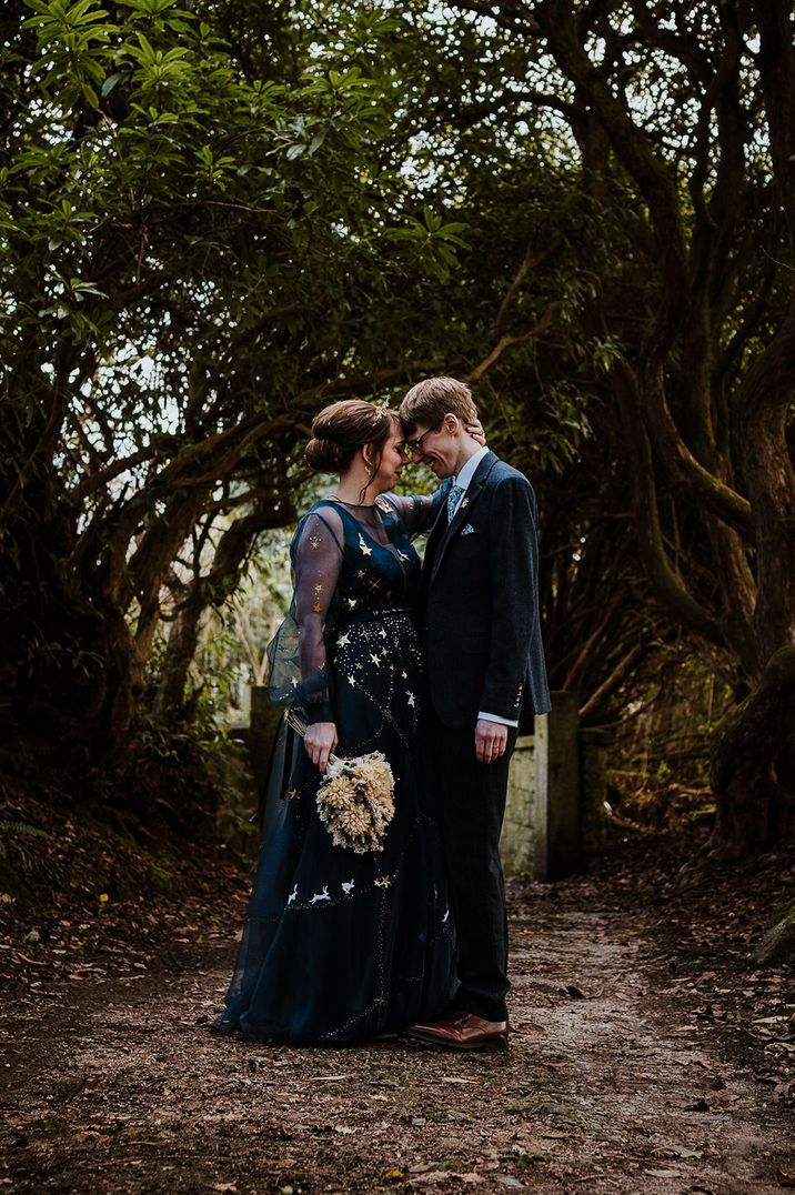 Bride wearing a bespoke dark navy blue wedding dress with gold stars for blue and celestial wedding theme 