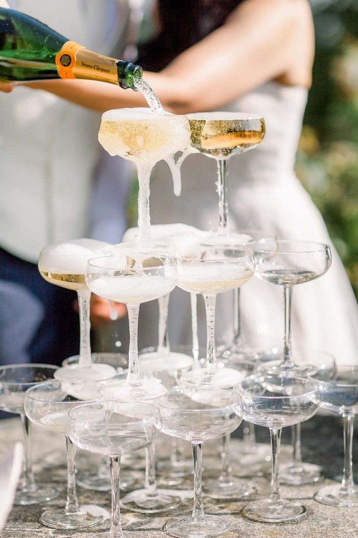 Newlyweds pouring champagne into the Champagne tower at wedding