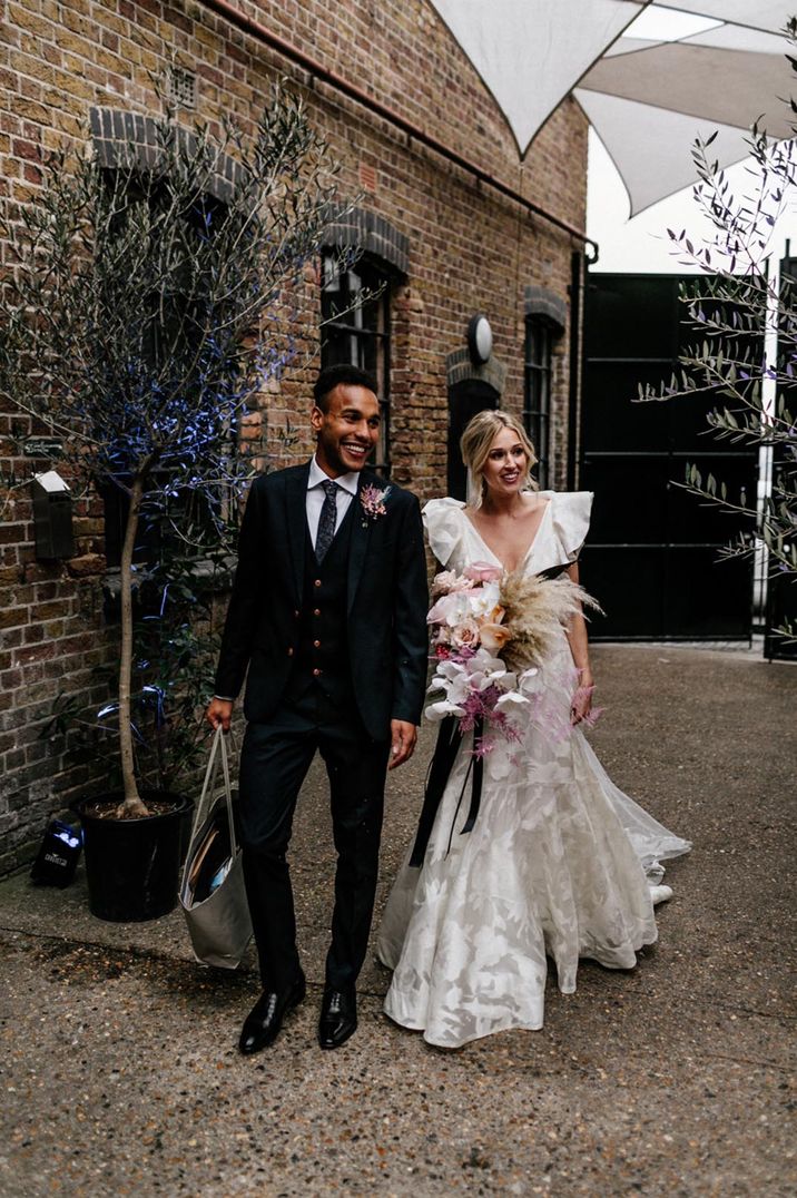 Bride in Jesus Peiro wedding dress and groom in black three piece suit 