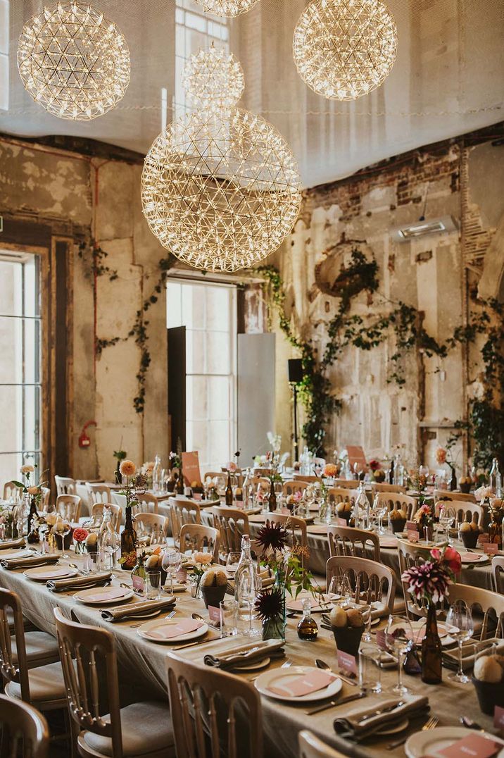 Rustic wedding venue with circular lighting with pink stationery wedding table settings by Virginia's Vintage Hire