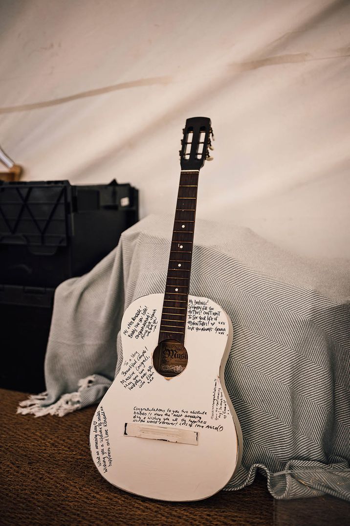 White guitar used as a wedding guest book for fun outdoor wedding 