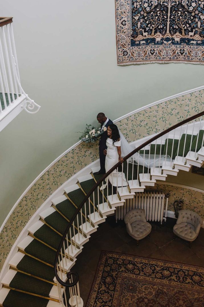 Bride and groom going down spiral staircase at Middleton Lodge Sudanese wedding