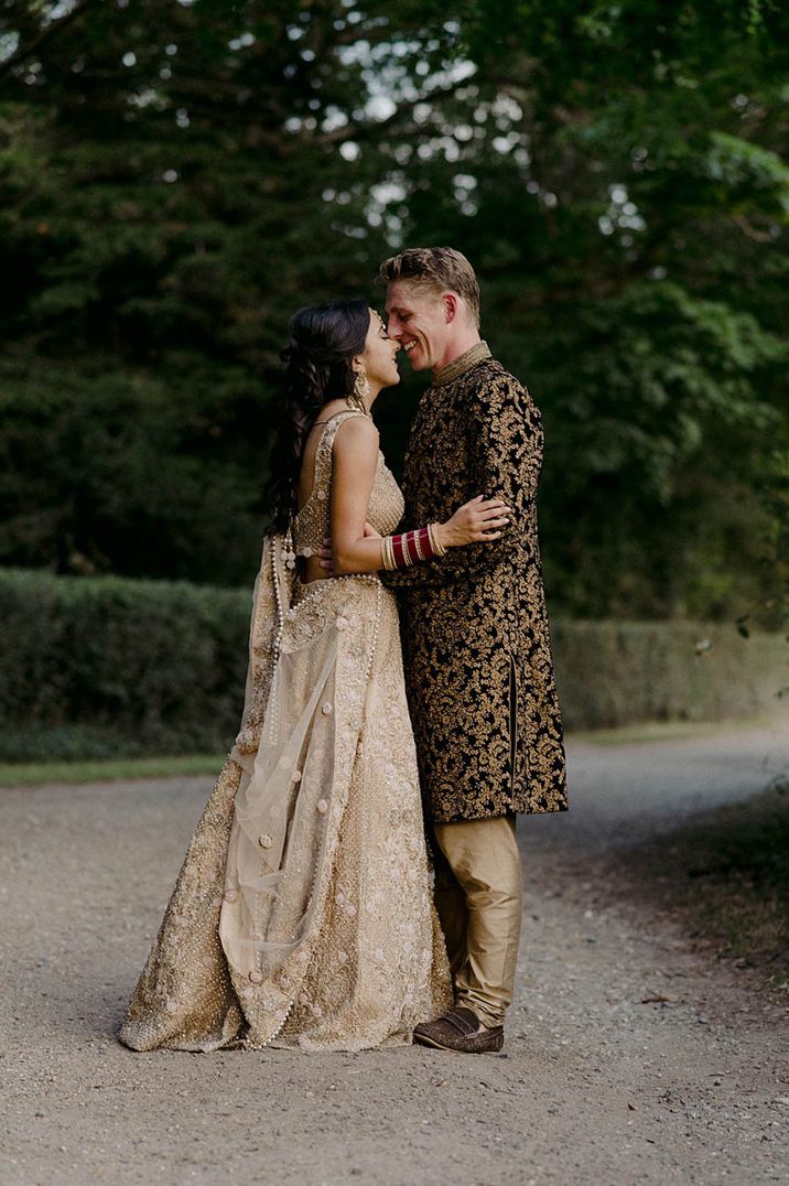 Bride and groom in brown and gold wedding outfits for traditional Hindu wedding ceremony 