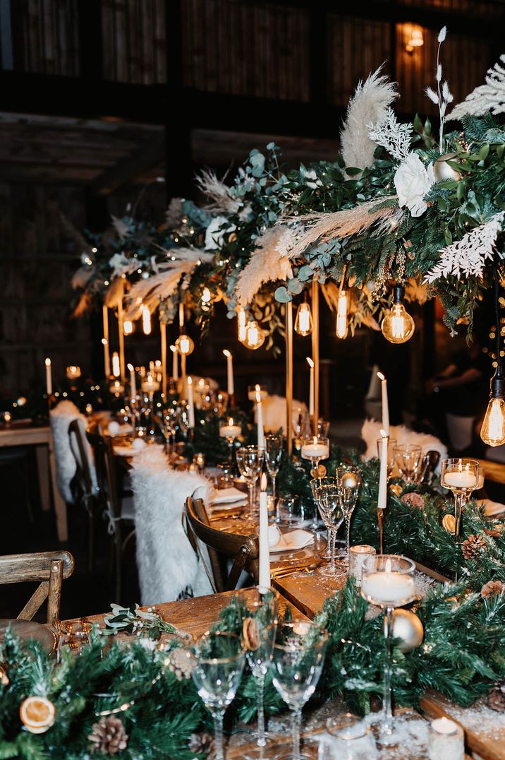 Fairy lights, faux fur, festoon lights and foliage decorate the wedding tablescape at this festive winter wedding 