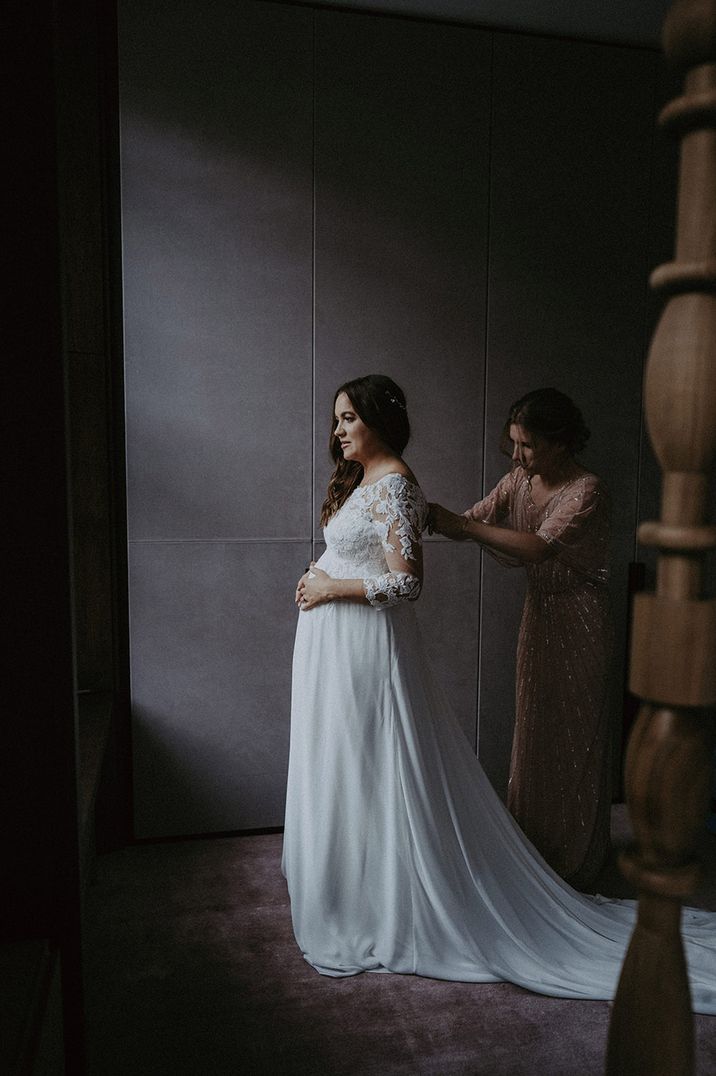 Bride in long sleeve lace wedding dress from the Pronovias maternity collection 