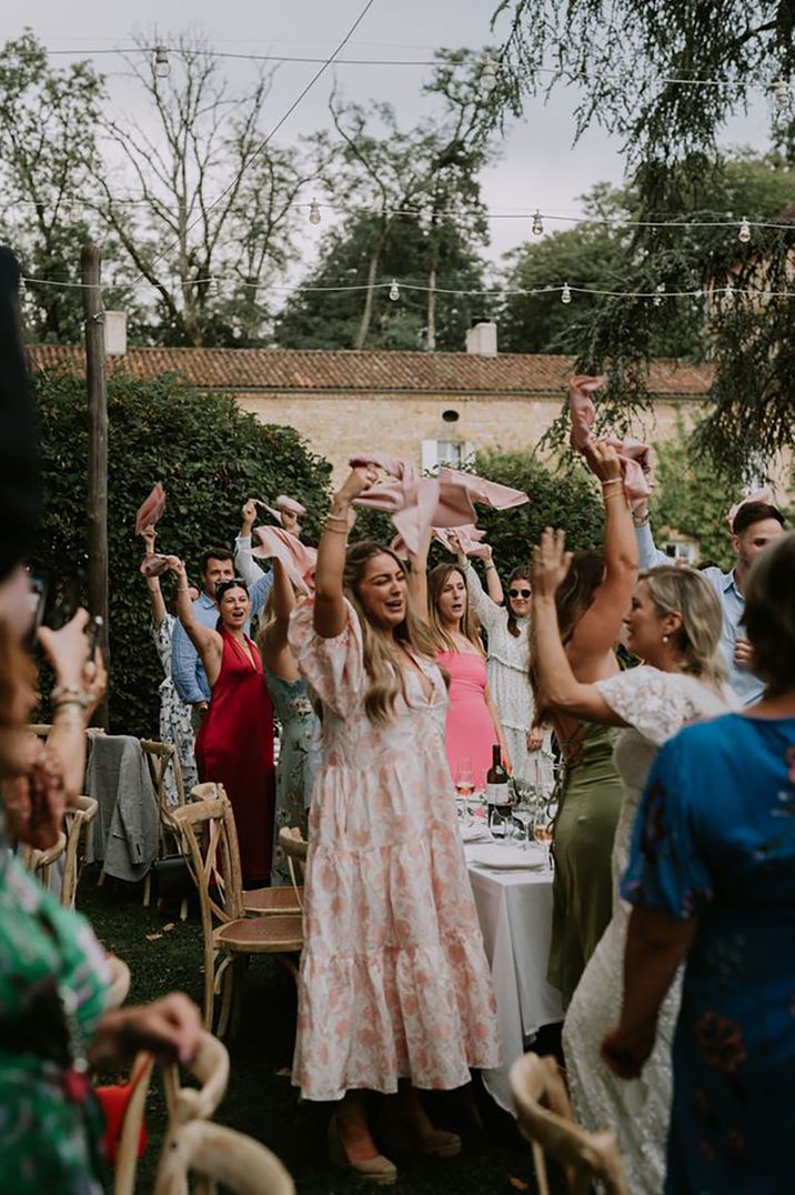 Wedding guests napkin swinging during reception at outdoor wedding wearing summer wedding guest dresses by HFP Photography